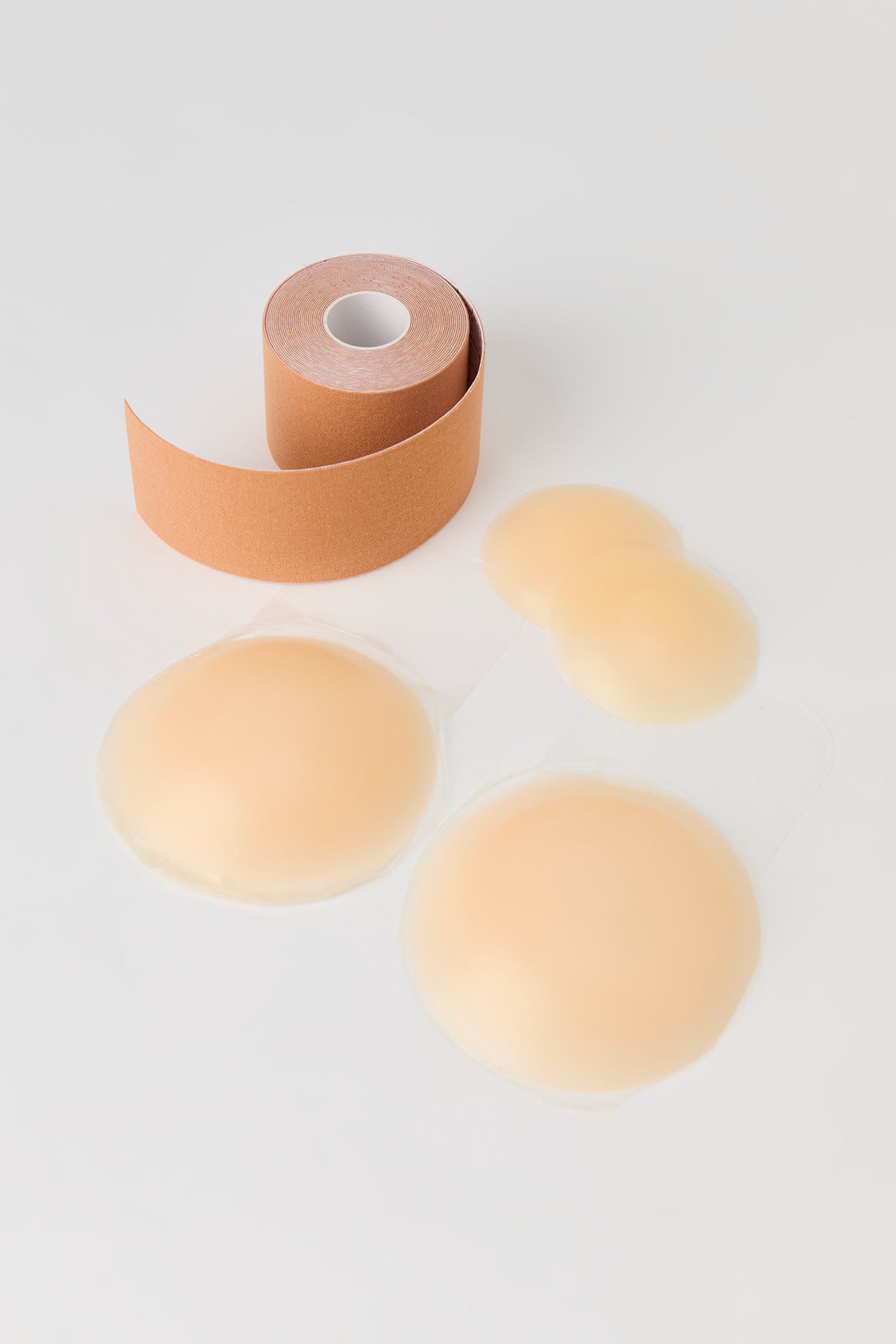 Ensemble avec bandes adhésives et cache-mamelons